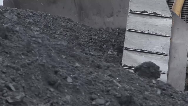 Bulldozer knife shoveling coal