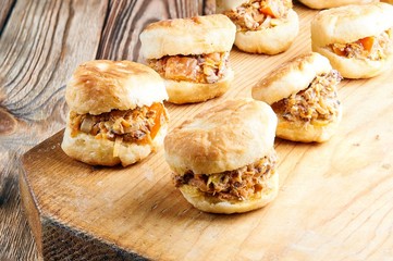 Vetkoek - typical African cuisine. Bread with a stuffing from Botswana. Sandwiches with fish, meat, vegetables. Mini burgers on a wooden board. High-calorie lunch, dinner.