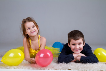 Fototapeta na wymiar Girl and boy with balloons in studio