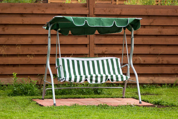 green metal swing on clover lawn