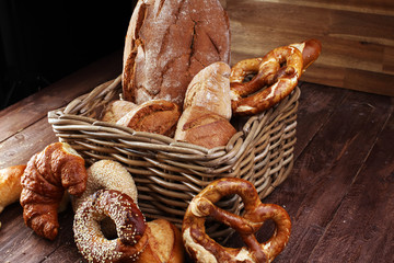 Different kinds of bread and bread rolls on board from above. Ki