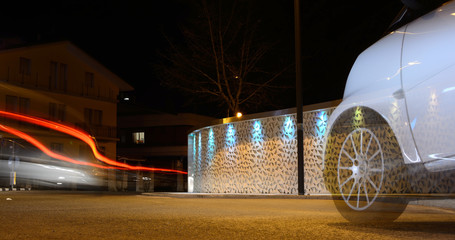 Night traffic in the city with modern art wall, Isernia, Italy