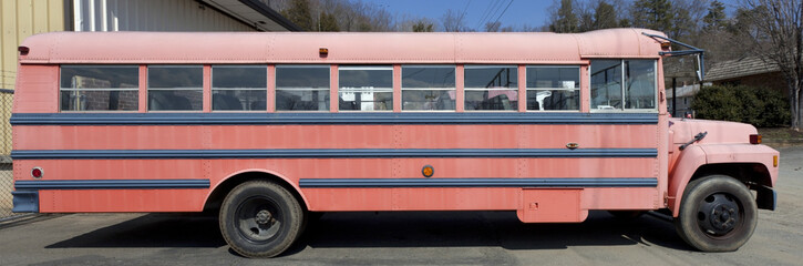 Side view of repainted and faded vintage school bus. Isolated.