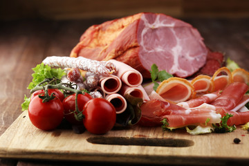 Food tray with delicious salami, pieces of sliced ham, sausage,