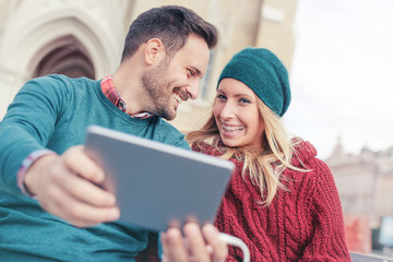 Young loving couple listening to music via tablet. Love, dating,