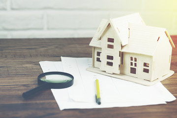 house model with magnifier on documents