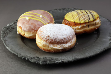 German donuts - berliner with jam and icing sugar in a tray on a