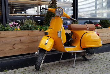 Chalkida, Greece - February 11, 2017: Yellow  scooter parked in a town Chalkida, Greece - Powered by Adobe