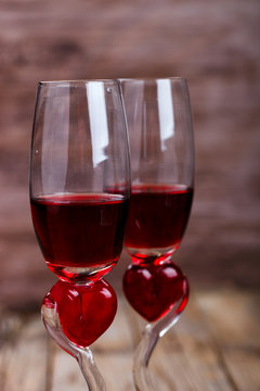 Two glasses in Heart shape with Red Wine on Old Wooden Background. Holiday Valentine's Day.Still Life.Vintage style.selective focus.