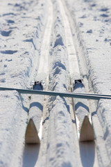 Healthy lifestyle wintersport. Cross-country skiing equipment on snow field. Crossed skis and ski...