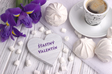 Still life with cup of coffe marshmallow zephyr iris flowers heart sign with lettering Happy Valentines Day in Slovak on white wooden background.