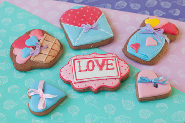 Honey cakes with glazed hearts and word love lay on different color background