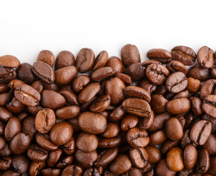 roasted coffee beans isolated in white background. Roasted coffee beans background close up. Coffee beans pile from top on white background with copy space for text. Good morning.