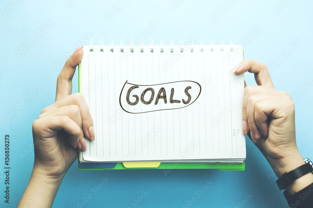 Poster goals text on notepad on woman hand