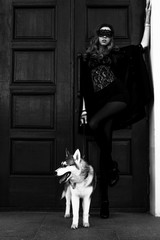 The girl with the siberian husky. Delightful girl plays with a Siberian Husky. Girl walking with a hunting dog - the West Siberian husky. Close-up. Fashion photo, black and white shot.