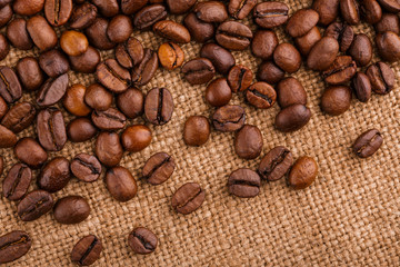 coffee beans on burlap background. roasted coffee beans isolated in white background. Roasted coffee beans background close up. Coffee beans pile from top on white background with copy space for text