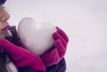 Girl lovingly gives icy heart.  Valentine's day.