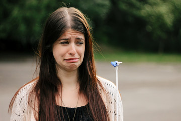 cute sad woman looking at banged blue balloon with crying emotio