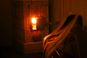 warm fireplace and wooden chair with woolen native blanket, cozy