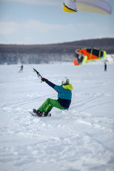 Men ski kiting on a frozen lake