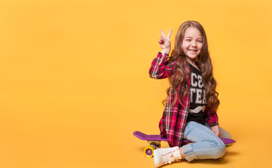 happy child girl laughing while sitting on skateboard