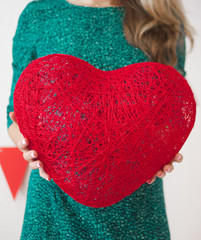 Young woman with the red heart in her hands