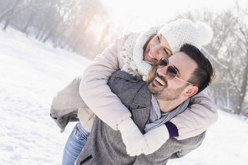 Smiling couple hugging and enjoying outdoors in winter
