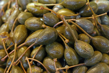 Green pickled big capers close up background