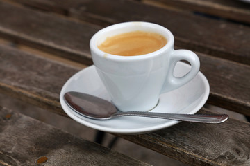 Espresso coffee in white cup close up on table
