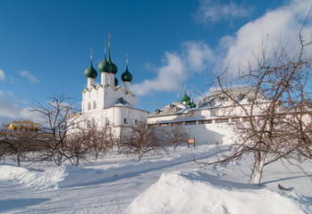 Fototapeta na wymiar Rostov Kremlin in winter day. Church of St. Gregory the Theologian and the House - view from the garden of the Metropolitan