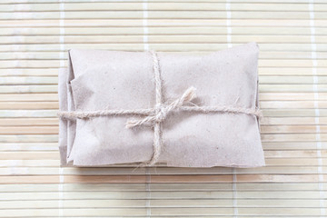 Wrapped parcel, paper package tied with burlap rope.