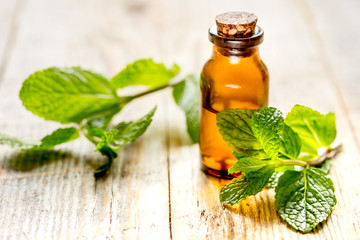 organic cosmetics with herbal extracts of mint on wooden background
