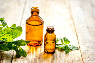 organic cosmetics with herbal extracts of mint on wooden background