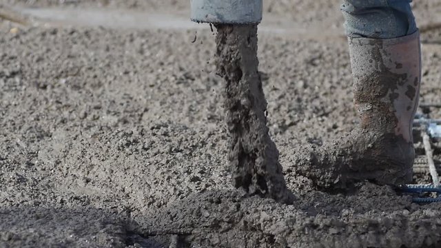 Slow Mo. Closeup. Pouring concrete mix on concreting formwork. Forming, an essential part of the entire building process. Close up, tracking shot.