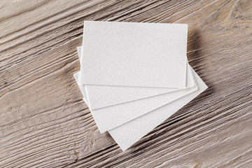 Mockup of business cards fan stack at textured wooden board back