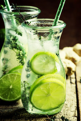 Lime Lemonade with thyme, ginger and ice. Vintage wooden backgro