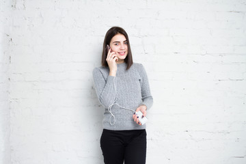 Powerbank in hands. Girl talking on the phone in smartphone and charges her phone. Young beautiful...