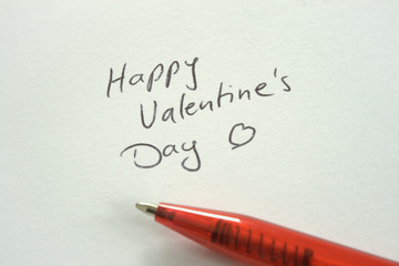 Handwritten Happy Valentine's Day congratulation on white paper