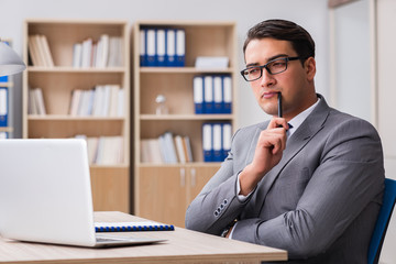 Fototapeta premium Young handsome businessman working on office