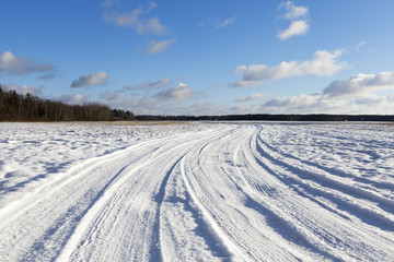 Fototapeta na wymiar traces of the car on snow