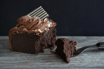 Rich chocolate cake with vintage fork on dark background
