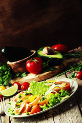 Salad with salted salmon and vegetables. Vintage wood background
