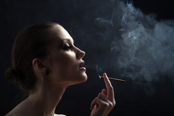 luxury woman smoking cigarette on black background