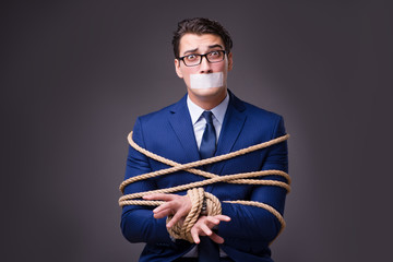 Businessman taken hostage and tied up with rope - obrazy, fototapety, plakaty