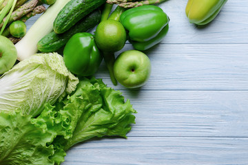 Green vegetables and fruits on wooden background