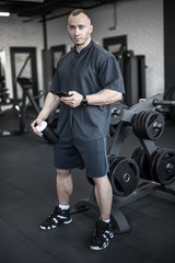 Fototapeta na wymiar Muscular man has pause in gym