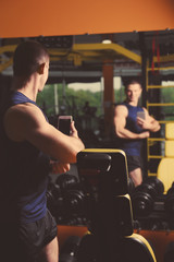 Fototapeta na wymiar Young handsome man taking selfie in gym