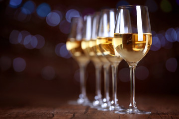 Glasses of wine in a row on bokeh background