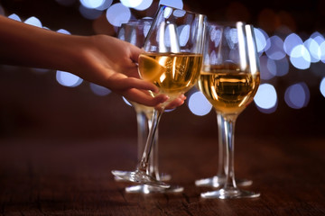 Female hand taking wine glass on bokeh background