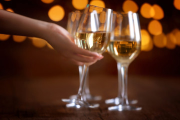 Female hand taking wine glass on bokeh background